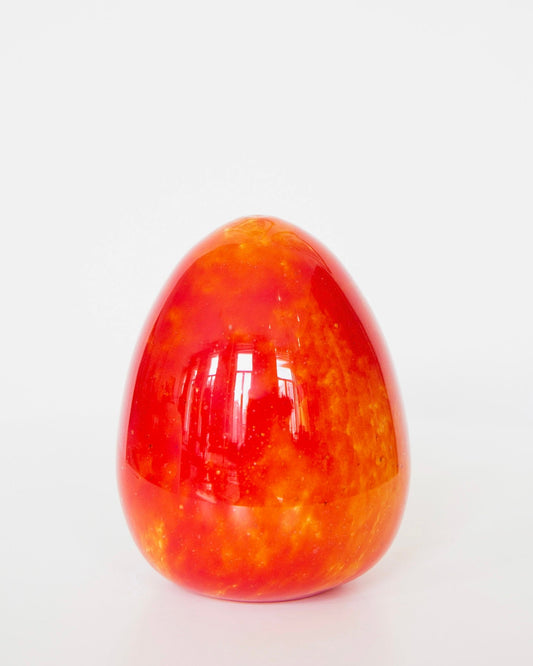 Red and orange marbled egg-shaped object on a white background